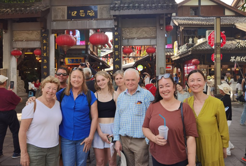 Tourists posing for a group photo under the archway in Ciqikou Ancient Town